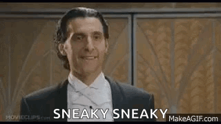 A Man In A Suit And Bow Tie Is Smiling And Says Sneaky Sneaky . GIF