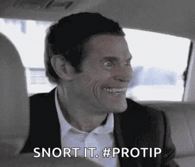 A Man In A Suit And Bow Tie Is Smiling In The Back Seat Of A Car . GIF