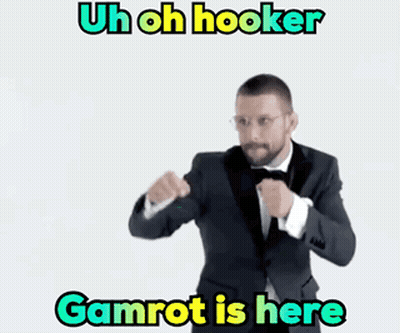 A Man In A Suit And Bow Tie Is Standing In Front Of A White Background With The Words Gamrot Is Here GIF