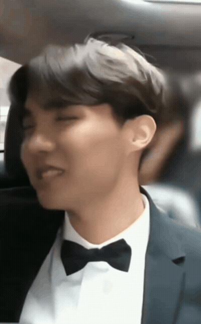 A Man In A Suit And Bow Tie Sitting In A Car GIF