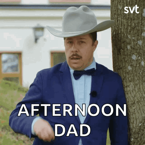 A Man In A Suit And Cowboy Hat Is Standing Next To A Tree And Says Afternoon Dad GIF