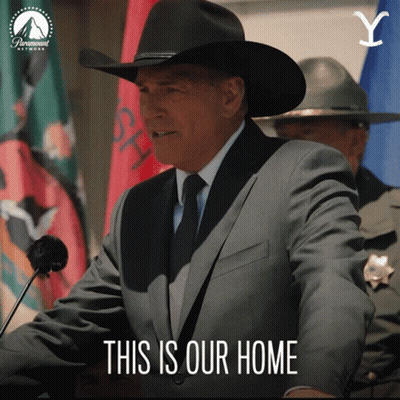 A Man In A Suit And Cowboy Hat Stands At A Podium With The Words " This Is Our Home " Below Him GIF