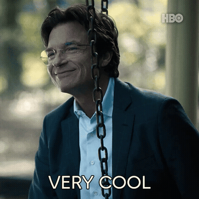 A Man In A Suit And Glasses Is Smiling While Sitting On A Swing With The Words " Very Cool " Below Him GIF