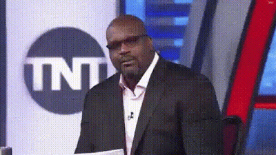 A Man In A Suit And Glasses Is Standing In Front Of A Tnt Logo GIF