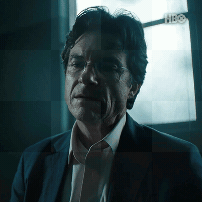 A Man In A Suit And Glasses Looks At The Camera With Hbo Written In The Corner GIF