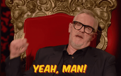 A Man In A Suit And Glasses Sits In A Red Chair With The Words Yeah Man Above Him GIF
