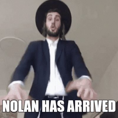 A Man In A Suit And Hat Is Dancing With The Words `` Nolan Has Arrived '' . GIF