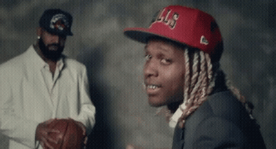 A Man In A Suit And Hat Is Holding A Basketball Next To Another Man In A Suit . GIF