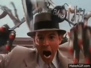 A Man In A Suit And Hat Is Holding A Bomb In His Hand And Screaming . GIF