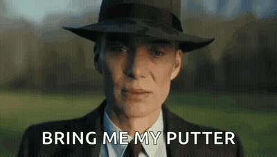 A Man In A Suit And Hat Is Standing In A Field With The Words `` Bring Me My Putter '' Written On The Screen . GIF