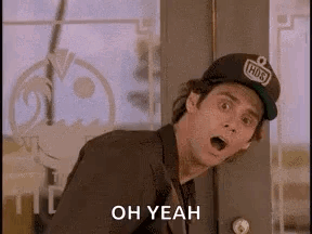 A Man In A Suit And Hat Is Standing In Front Of A Door With His Mouth Open And Says `` Oh Yeah '' . GIF