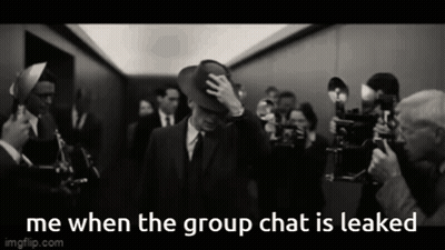 A Man In A Suit And Hat Is Surrounded By A Crowd Of People And The Caption Says Me When The Group Chat Is Leaked GIF