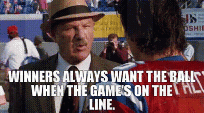 A Man In A Suit And Hat Is Talking To A Man In A Red Shirt . GIF