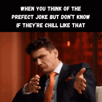 A Man In A Suit And Orange Tie Is Making A Funny Face GIF