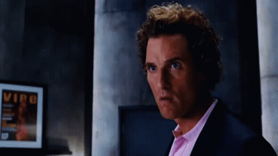 A Man In A Suit And Pink Shirt Is Standing In Front Of A Framed Picture That Says Vip On It GIF