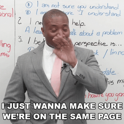 A Man In A Suit And Pink Tie Is Covering His Nose In Front Of A Whiteboard That Says I Just Wanna GIF