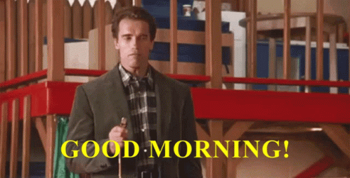 A Man In A Suit And Plaid Shirt Is Holding A Cane In Front Of A Sign That Says " Good Morning " GIF