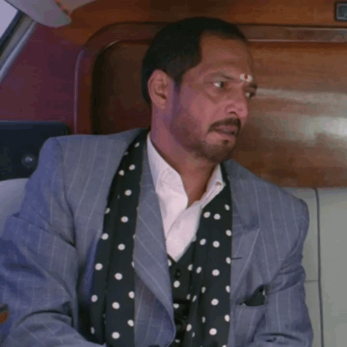 A Man In A Suit And Polka Dot Scarf Is Sitting In A Car With The Words Ye Raaz Bi Usi K Saath Ch GIF