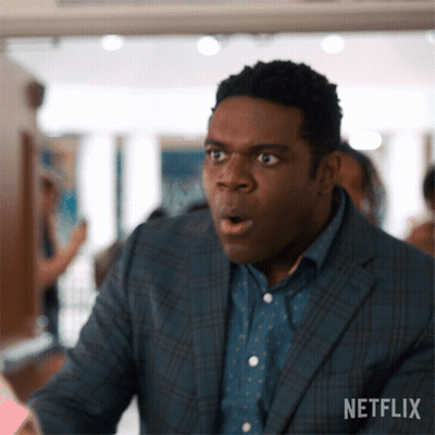 A Man In A Suit And Polka Dot Shirt Looks Surprised With His Mouth Open .. GIF