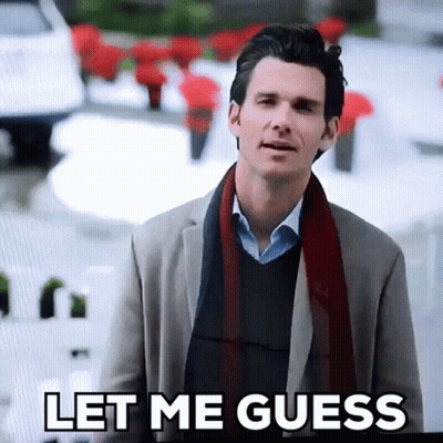 A Man In A Suit And Scarf Is Standing In Front Of A Sign That Says Let Me Guess GIF