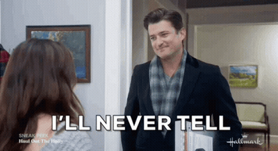 A Man In A Suit And Scarf Is Talking To A Woman In A Hallway . GIF