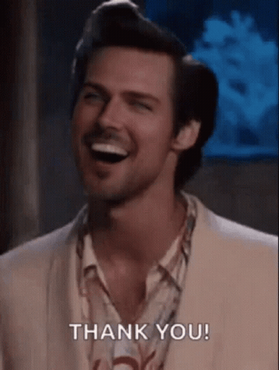 A Man In A Suit And Shirt Is Laughing And Saying Thank You . GIF