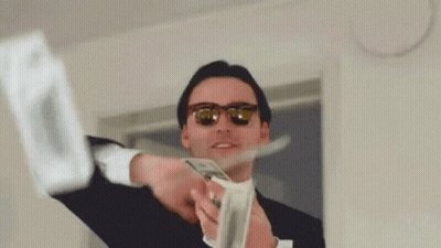 A Man In A Suit And Sunglasses Is Holding A Bunch Of Money And Throwing It In The Air . GIF