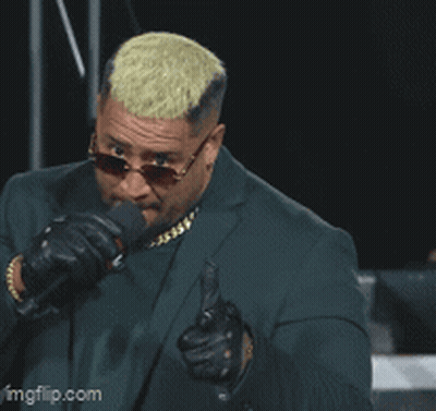 A Man In A Suit And Sunglasses Is Pointing A Gun At The Camera With The Caption Pew GIF