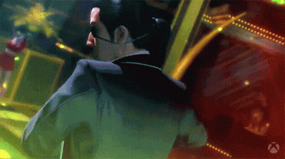 A Man In A Suit And Sunglasses Stands In Front Of A Xbox Logo GIF