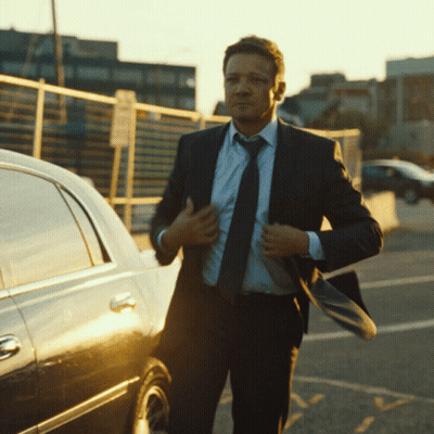 A Man In A Suit And Tie Adjusts His Tie GIF