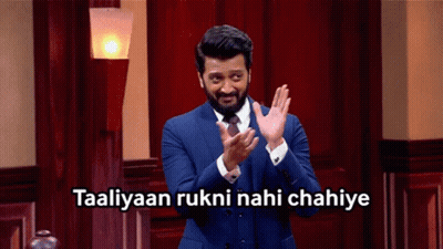 A Man In A Suit And Tie Applauds With The Words Taaliyaan Rukni Nahi Chahiye Above Him GIF