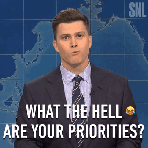 A Man In A Suit And Tie Asking What The Hell Are Your Priorities GIF