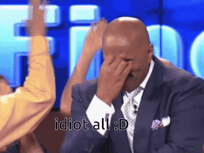 A Man In A Suit And Tie Covering His Face With His Hand With The Words Idiot All : D Written Below Him GIF