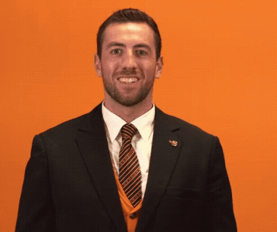 A Man In A Suit And Tie Covering His Mouth GIF