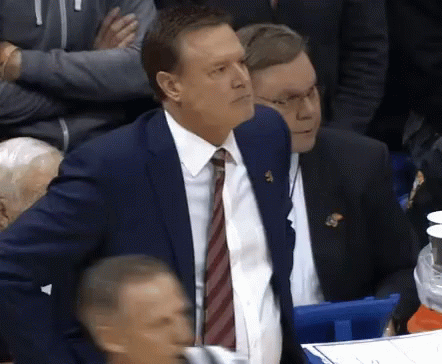 A Man In A Suit And Tie Has A Badge On His Chest That Says Kc On It GIF