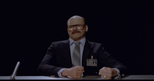 A Man In A Suit And Tie Has A Name Tag With A Picture Of A Person On It GIF