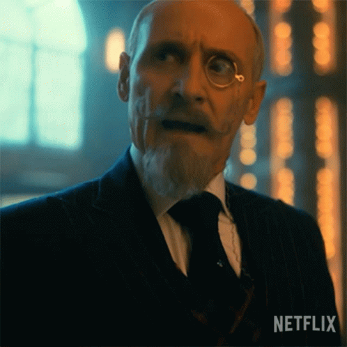 A Man In A Suit And Tie Has A Netflix Logo On The Bottom Left GIF