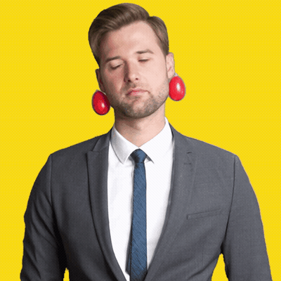 A Man In A Suit And Tie Has A Pair Of Red Eggs In His Ears GIF