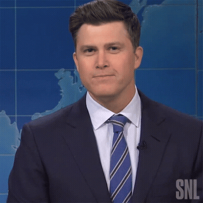 A Man In A Suit And Tie Has A Snl Logo On His Shirt GIF