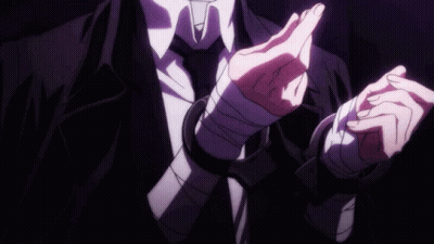 A Man In A Suit And Tie Has His Hands Wrapped In Bandages And Handcuffs . GIF
