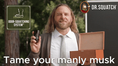 A Man In A Suit And Tie Holding A Bottle Of Odor Squatting System GIF