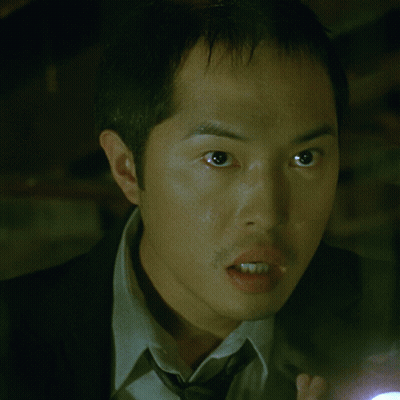 A Man In A Suit And Tie Holding A Flashlight GIF