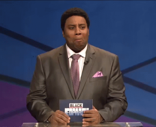 A Man In A Suit And Tie Holds A Black Empire Sign GIF