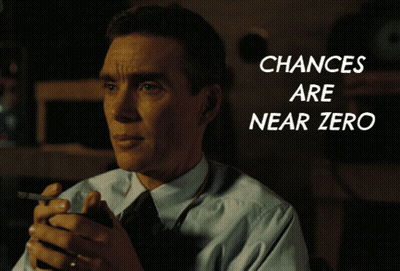 A Man In A Suit And Tie Holds A Cell Phone In Front Of A Screen That Says Chances Are Near Zero GIF