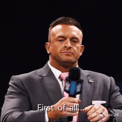 A Man In A Suit And Tie Holds A Microphone And Says " First Of All ... " GIF