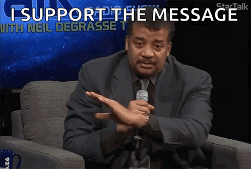 A Man In A Suit And Tie Holds A Microphone And Says I Support The Message With Neil Degrasse T. GIF