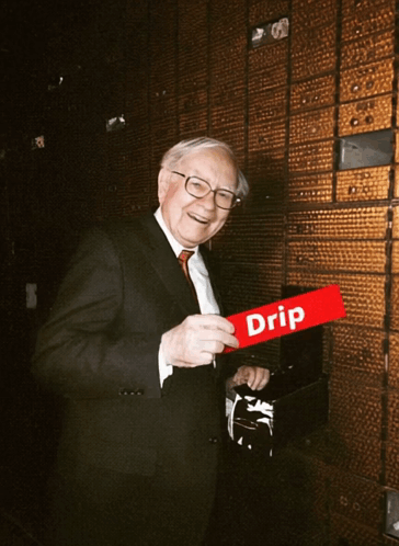 A Man In A Suit And Tie Holds A Red Sign That Says Drip GIF