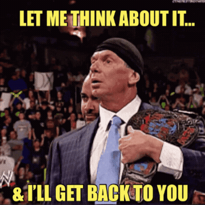 A Man In A Suit And Tie Holds A Wrestling Championship Belt And Says Let Me Think About It GIF