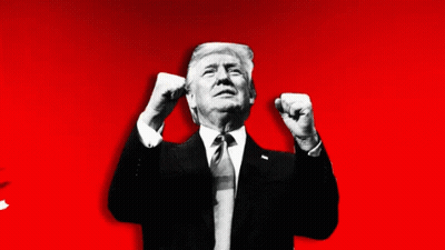 A Man In A Suit And Tie Holds His Fist In The Air GIF