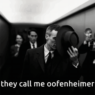 A Man In A Suit And Tie Holds His Hat Over His Face With The Words They Call Me Oofenheimer Below Him GIF